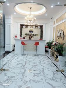 a lobby with a marble floor and a bar with red stools at Nice Dream Hotel in Yen