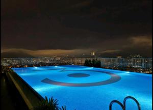 a large blue swimming pool at night with a city skyline at 3 Towers Duplex KLCC in Kuala Lumpur