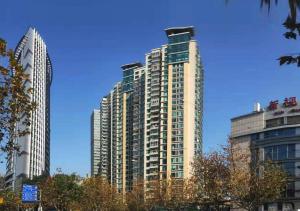 zwei hohe Gebäude in einer Stadt mit blauem Himmel in der Unterkunft Shanghai Jiarong Hotel Apartment in Shanghai