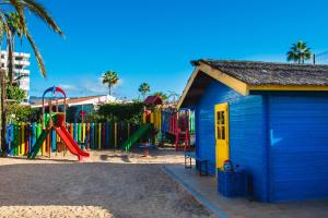 un parque infantil con un pequeño edificio azul y una estructura de juegos en HL Miraflor Suites Hotel, en Playa del Inglés
