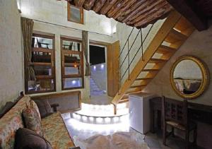 a living room with a couch and a staircase at Perimasali Cave Hotel - Cappadocia in Ürgüp
