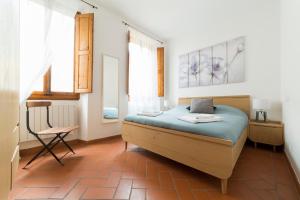 1 dormitorio con 1 cama y 1 silla en Santa Maria Novella 6 sleeps near the central station, en Florencia