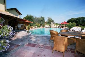 un patio con mesa y sillas junto a una piscina en Hotel Gasthof-Strasser en Tumeltsham