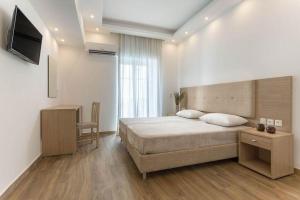 a bedroom with a bed and a television in it at Mare Naxia Hotel in Naxos Chora