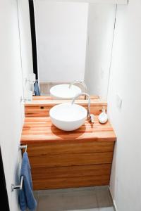 a bathroom with a white bowl sink on a wooden counter at Departamento Aeropuerto Circunvalacion Kempes Quorum -cambio oficial- in Córdoba