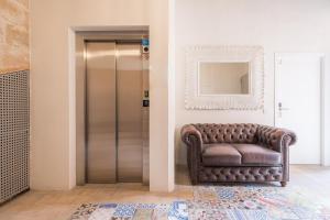 una silla de cuero marrón en un pasillo con espejo en Vintage Palma Palace Apartments TI, en Palma de Mallorca