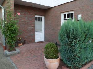 ein Backsteinhaus mit einer weißen Tür und einigen Pflanzen in der Unterkunft Ferienwohnung_Beethovenstrasse in Westerstede