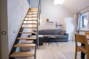 eine Wendeltreppe in einem Wohnzimmer mit einem Sofa in der Unterkunft Cesa Civetta in Canazei