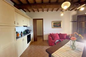 cocina y sala de estar con mesa en Il Poggio Della Pieve Apartments, en Santa Luce