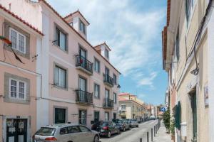 a street with cars parked on the sides of buildings at Beautiful Apartment with View of the Tagus River in Lisbon