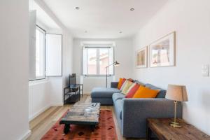 a living room with a blue couch and a table at Beautiful Apartment with View of the Tagus River in Lisbon