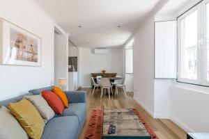 a living room with a blue couch and a table at Beautiful Apartment with View of the Tagus River in Lisbon