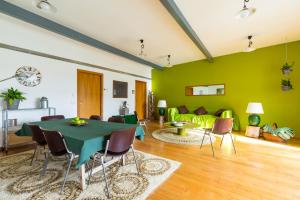 a living room with a table and a green wall at KaMyHouse Una tranquilla struttura nel verde in Naples