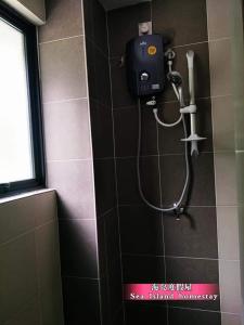 een douche in een badkamer met een zeepdispenser aan de muur bij 邦咯海岛度假屋 Pangkor Sea Island in Pangkor