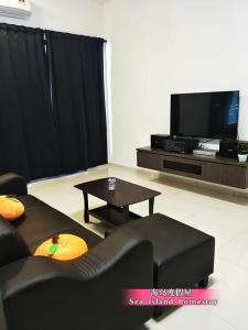 een woonkamer met een bank, een tafel en een tv bij 邦咯海岛度假屋 Pangkor Sea Island in Pangkor
