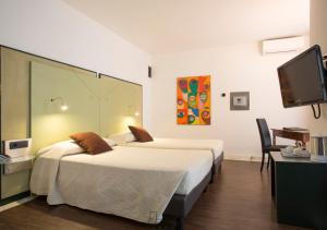 pokój hotelowy z 2 łóżkami i telewizorem z płaskim ekranem w obiekcie Hotel Buonconsiglio w Trydencie