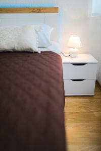 ein Schlafzimmer mit einem Bett und einem Nachttisch mit einer Lampe in der Unterkunft Apartment Havana in Zadar