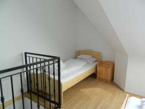 a small bedroom with a bed and a staircase at Família-Pelso apartmanház in Zamárdi