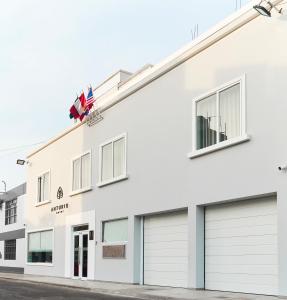 un edificio blanco con dos puertas de garaje en Anturio Hotel, en Trujillo