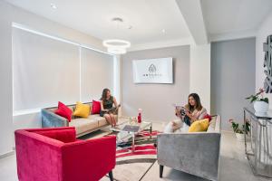 Dos mujeres sentadas en sofás en una sala de estar en Anturio Hotel, en Trujillo