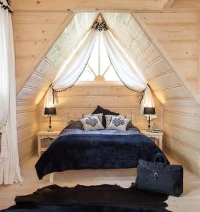 a bedroom with a large bed with a window at TatryTop Osada Luxury Chalets Kościelisko in Kościelisko