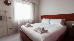 Un dormitorio con una cama blanca con toallas. en Italianway - Bassini 31 en Milán