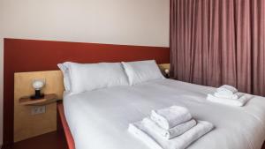Una habitación de hotel con una cama con toallas. en Italianway - Bassini 31 en Milán