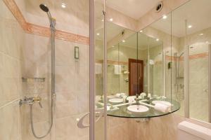 
a bathroom with a tub, shower, and sink at Golf Hotel René Capt in Montreux
