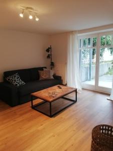 a living room with a black couch and a coffee table at Seepferdchen in Timmendorfer Strand