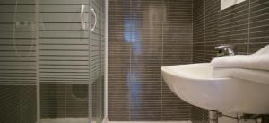 ein Bad mit einem Waschbecken, einer Dusche und einem Waschbecken in der Unterkunft Appartement Gare Lille Europe in Lille