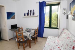 d'une salle à manger avec une table, des chaises et une fenêtre. dans l'établissement Casa Rosa appartamento con giardino, à Cetara