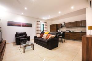 a living room with a couch and a kitchen at Valletta Triton Apartment in Valletta