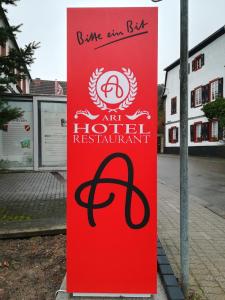 a sign for an art hotel restaurant on a street at Hotel Ari in Kaiserslautern