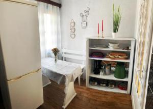 a small kitchen with a table and a refrigerator at Căsuța Măriei in Borşa