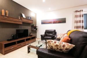 a living room with a couch and a television at Valletta Triton Apartment in Valletta