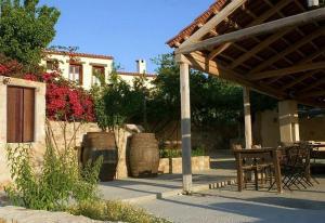 un patio avec une table et un banc sous un pavillon dans l'établissement Sarris House, à Xirokámbion