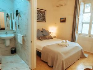 a bedroom with a bed and a sink and a bathroom at The Maltese Sun in Sliema