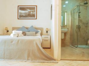 a bedroom with a bed and a glass shower at The Maltese Sun in Sliema