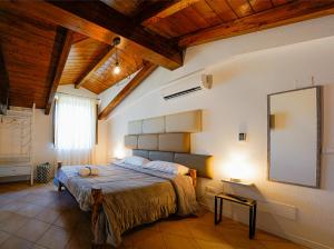 Cascina San Michele في فيشانو: غرفة نوم بسرير كبير في غرفة بسقوف خشبية