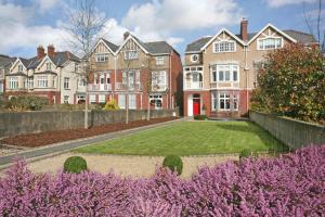 a large house with a yard with purple flowers at The Red Door in Limerick