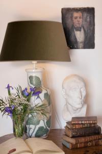 a table with a lamp and a vase with a bust at La Venteta in Aigues