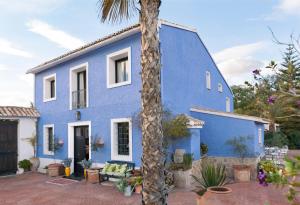 a blue house with a palm tree in front of it at La Venteta in Aigues