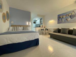 une grande chambre avec un lit et un canapé dans l'établissement MiNERVA, à Benalmádena