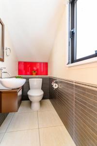 łazienka z toaletą, umywalką i oknem w obiekcie Villa Amaryllis w mieście Protaras