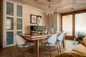 a dining room with a wooden table and white chairs at B&B LUNA in Cornedo Vicentino +33 photos