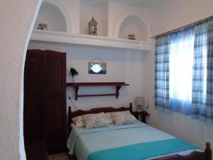 1 dormitorio con cama y ventana en Ostria Studios - Spilia en Síkinos