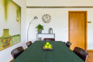 a dining room with a green table with fruit on it at KaMyHouse Una tranquilla struttura nel verde in Naples