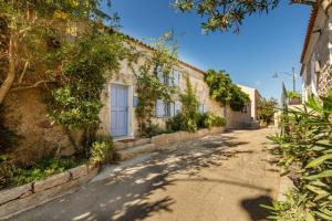 un bâtiment avec une porte bleue dans une rue dans l'établissement Charming Cottage Il Glicine a San Pantaleo, à San Pantaleo