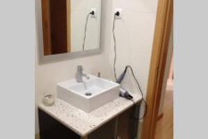 a bathroom with a white sink and a mirror at Apartamento Varandas Soalheiras in Odeceixe