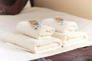 a pile of white towels sitting on a bed at Villa Kamakura in Kamakura